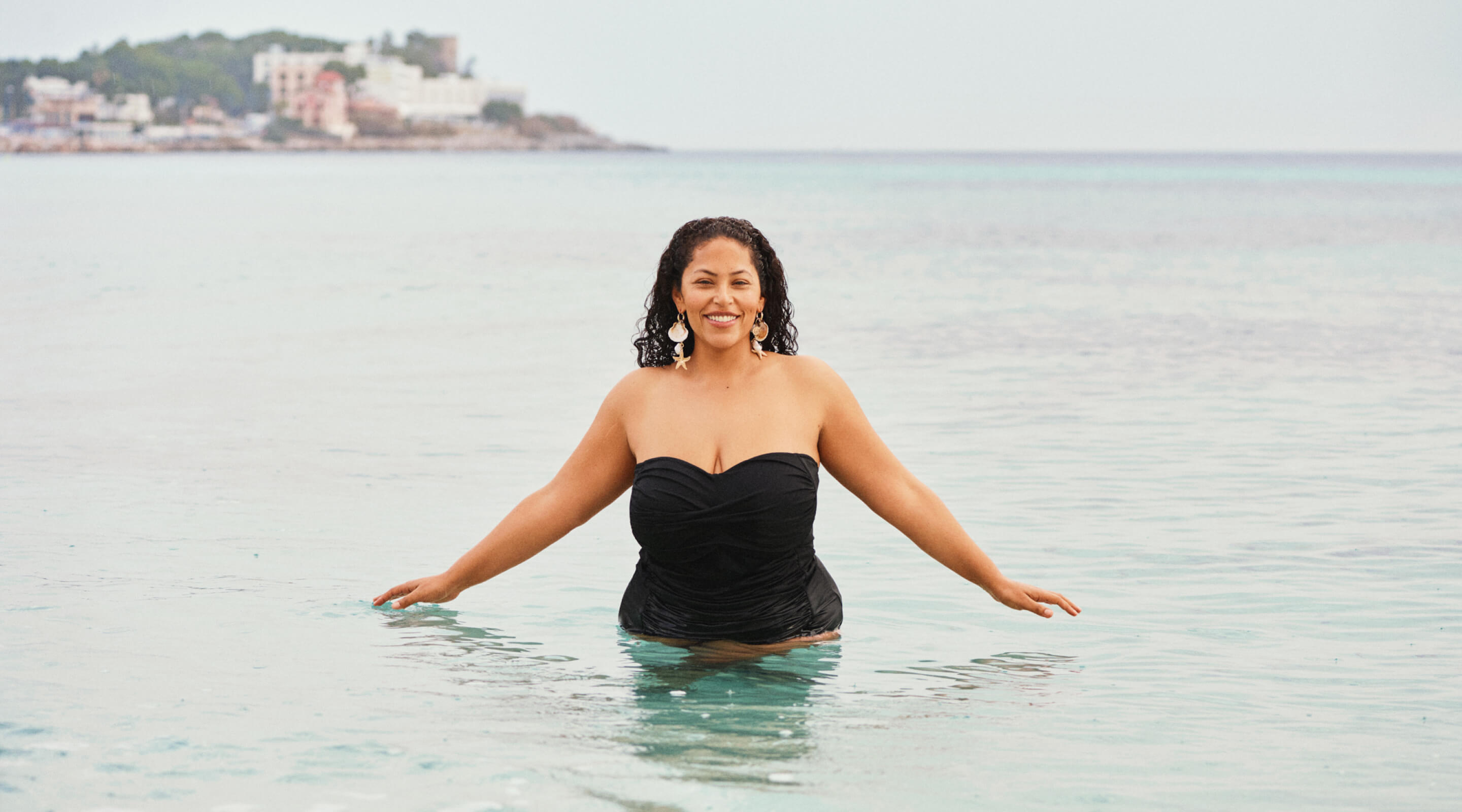 Model in een wit bikinibovenstuk bij de haven met zwemmers